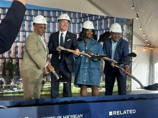 Groundbreaking ceremony with four participants in hard hats holding shovels at Related Companies University of Michigan project