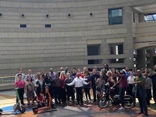 Group gathered outside modern building at mobility event